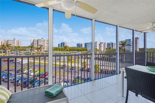 sunroom featuring a city view and ceiling fan