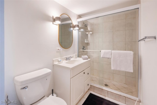 full bathroom featuring a shower stall, toilet, and vanity