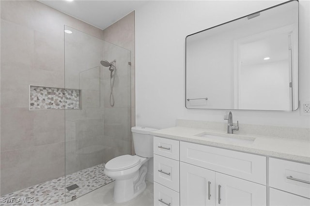 full bath featuring vanity, toilet, and tiled shower