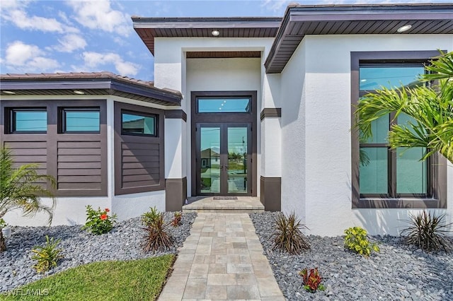 property entrance with french doors and stucco siding