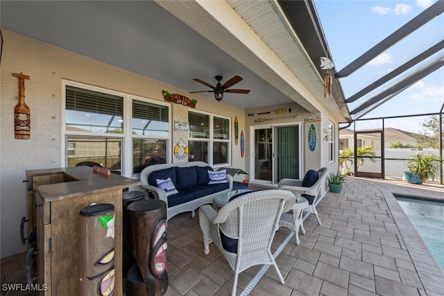 view of patio featuring ceiling fan, an outdoor living space, an outdoor bar, and glass enclosure