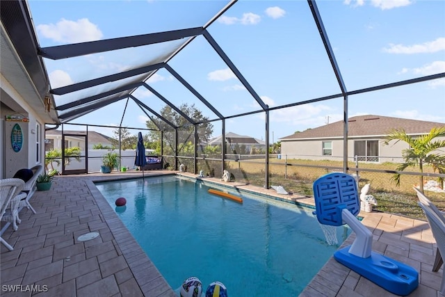 view of pool featuring glass enclosure and a patio area