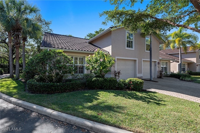 mediterranean / spanish home with a front yard and a garage