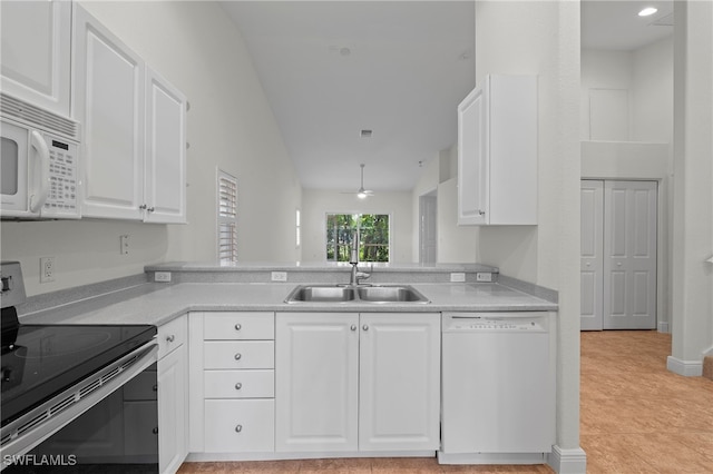 kitchen featuring white appliances, sink, light tile patterned floors, white cabinets, and lofted ceiling