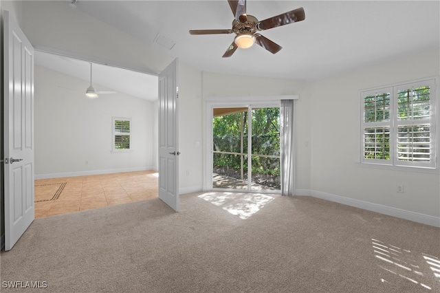 carpeted empty room featuring ceiling fan, plenty of natural light, and lofted ceiling