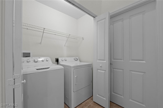 clothes washing area featuring washer and dryer and light tile patterned flooring