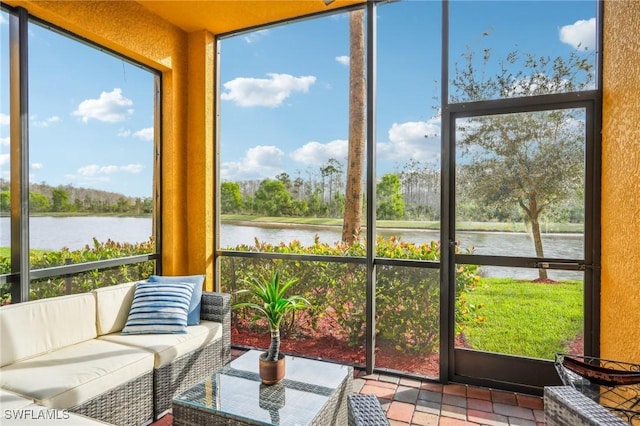 sunroom with plenty of natural light and a water view