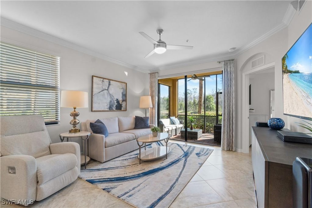 living room featuring ceiling fan, light tile patterned floors, and crown molding