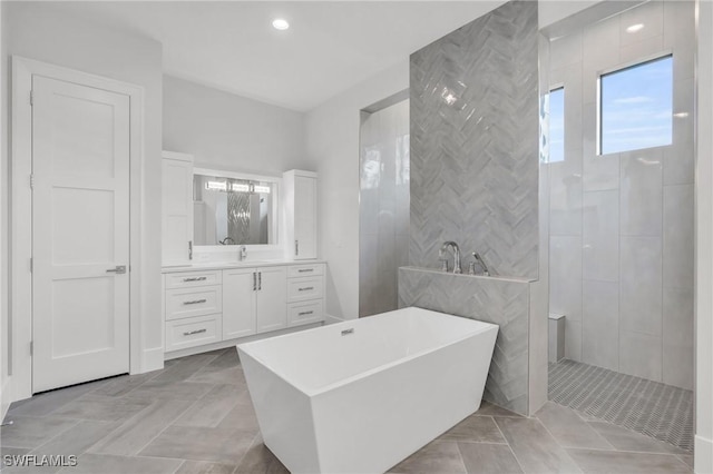 bathroom featuring tile patterned flooring, vanity, tile walls, and independent shower and bath