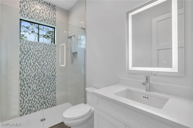 bathroom featuring vanity, toilet, and a shower with shower door