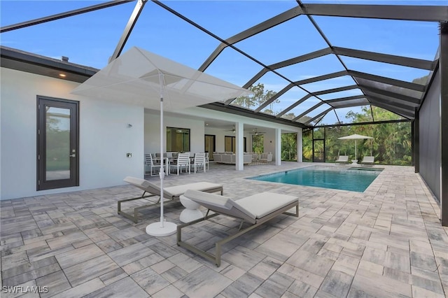 view of swimming pool with a lanai, outdoor lounge area, ceiling fan, and a patio