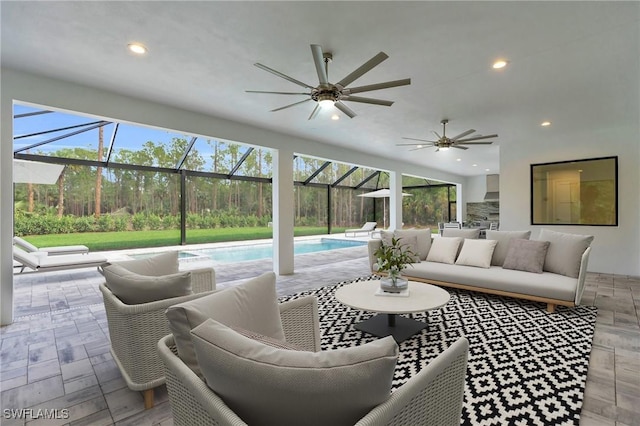 view of patio / terrace with an outdoor living space, ceiling fan, and a lanai