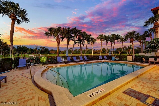 pool at dusk with a patio area