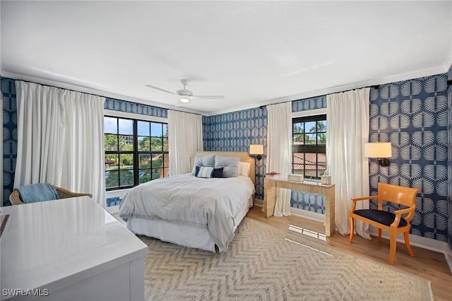 bedroom with multiple windows, ceiling fan, and light wood-type flooring