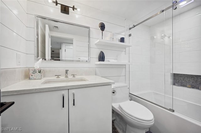 full bathroom featuring combined bath / shower with glass door, vanity, toilet, and wood walls