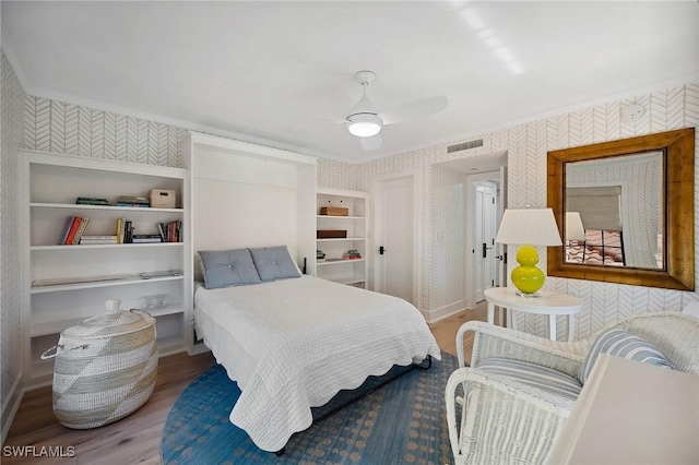 bedroom featuring wood-type flooring, ceiling fan, and crown molding