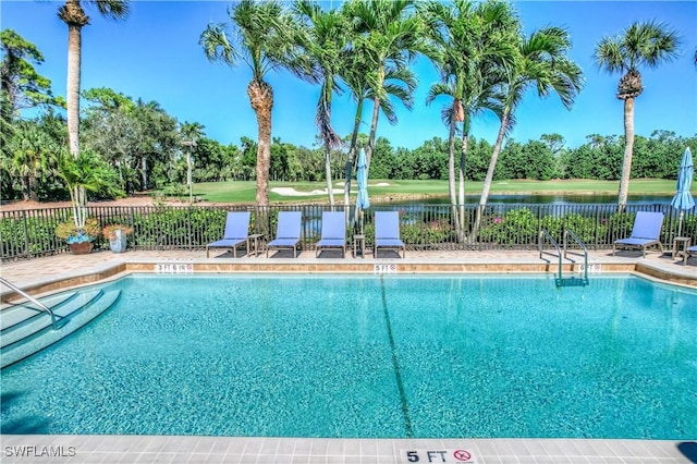 view of pool with a water view and a patio area