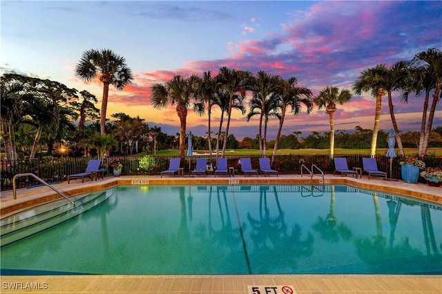 pool at dusk featuring a patio