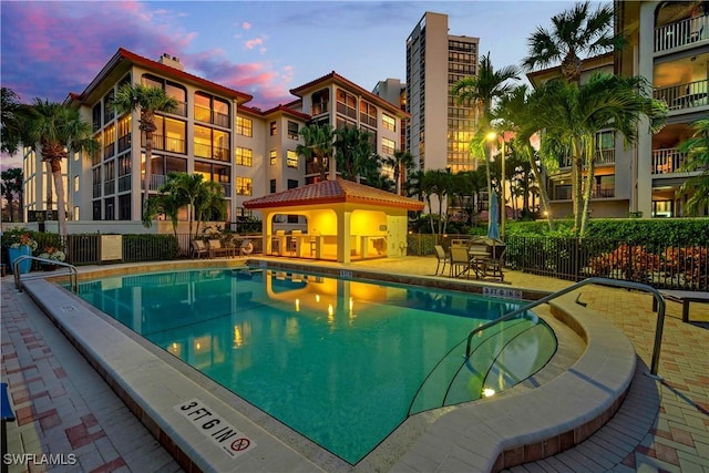 pool at dusk featuring a patio