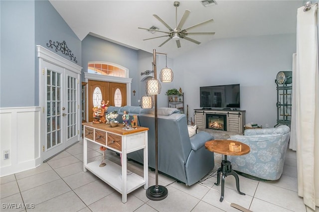 tiled living room with ceiling fan, lofted ceiling, and french doors