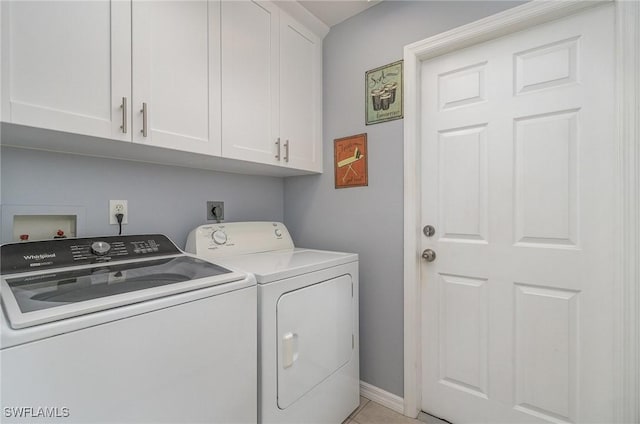 washroom with washer and dryer and cabinets