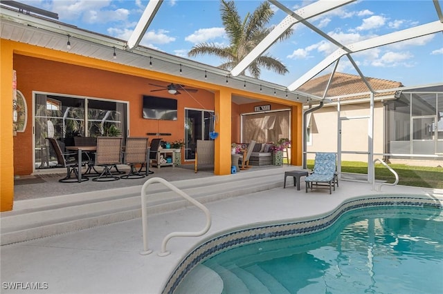 view of swimming pool featuring ceiling fan, a patio area, and glass enclosure