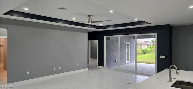 bedroom with a raised ceiling, sink, and access to outside