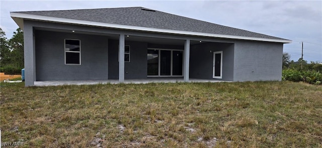 back of property with a yard and a patio area