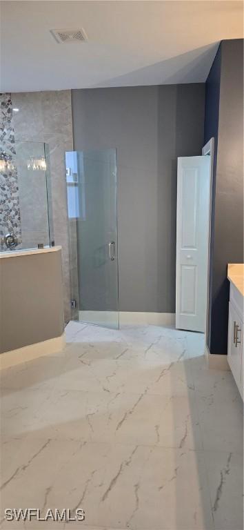 bathroom featuring vanity and a shower with door