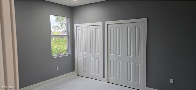 unfurnished bedroom with two closets