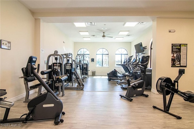 workout area with ceiling fan and light hardwood / wood-style floors