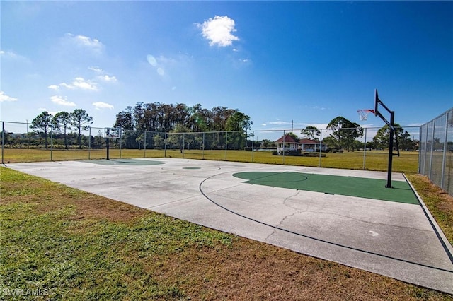 view of basketball court with a yard