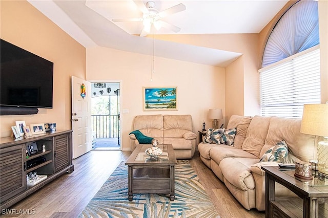 living room with ceiling fan, hardwood / wood-style floors, and vaulted ceiling