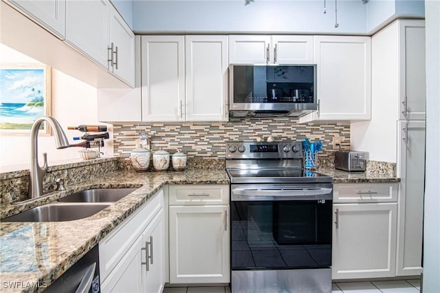 kitchen featuring light stone counters, stainless steel appliances, white cabinetry, and sink