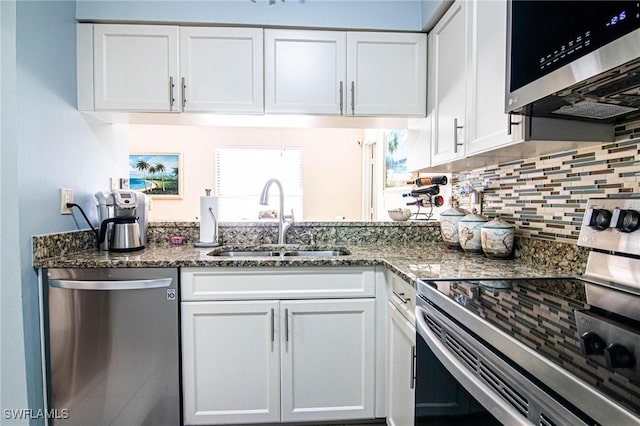 kitchen featuring white cabinetry, sink, dark stone counters, and appliances with stainless steel finishes