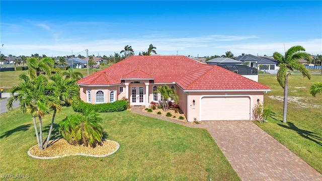 mediterranean / spanish-style house with french doors, a garage, and a front lawn