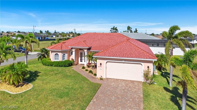 mediterranean / spanish home with a front yard, french doors, and a garage