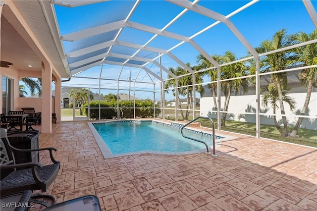 view of pool with glass enclosure and a patio area