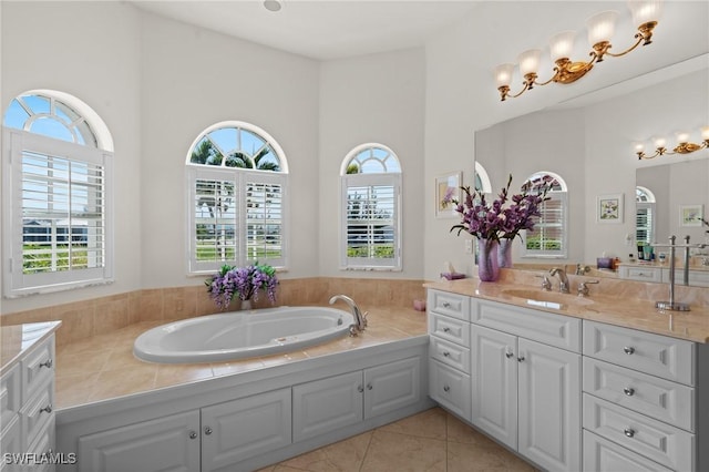 bathroom featuring tile patterned floors, plenty of natural light, a washtub, and vanity