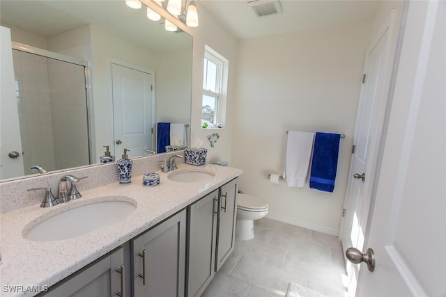 bathroom featuring vanity, toilet, a shower with shower door, and tile patterned flooring