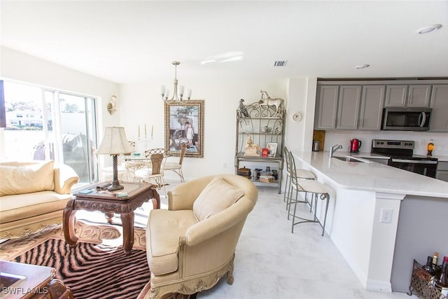 living room with an inviting chandelier and sink