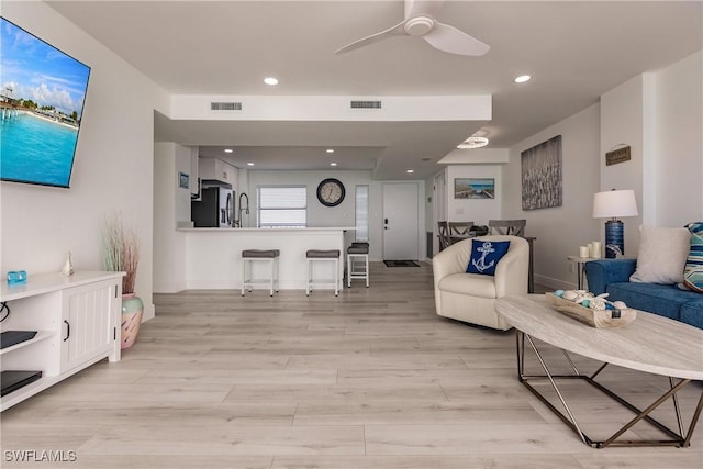 living room with ceiling fan and light hardwood / wood-style floors