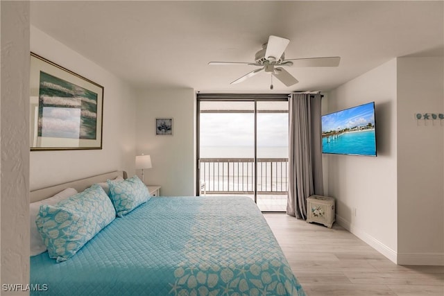 bedroom featuring access to exterior, ceiling fan, expansive windows, and light wood-type flooring