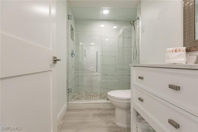 bathroom featuring wood-type flooring, an enclosed shower, and toilet