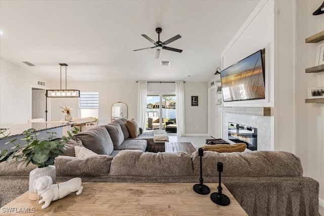 living room featuring light hardwood / wood-style floors, vaulted ceiling, ceiling fan, and a premium fireplace