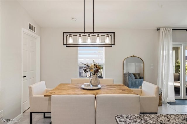 tiled dining space with a chandelier