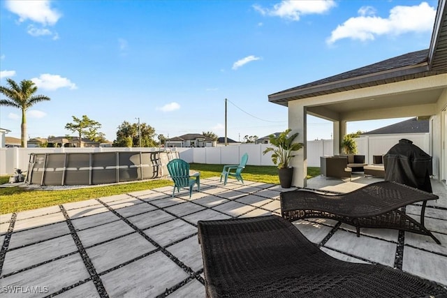 view of patio / terrace featuring outdoor lounge area, a fenced in pool, and a grill