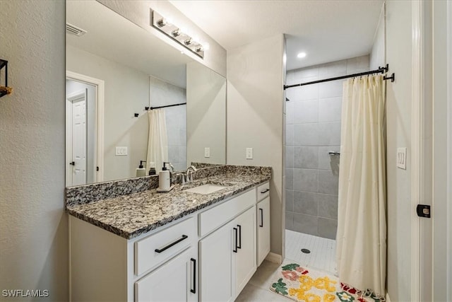 bathroom featuring a shower with curtain, vanity, and tile patterned flooring