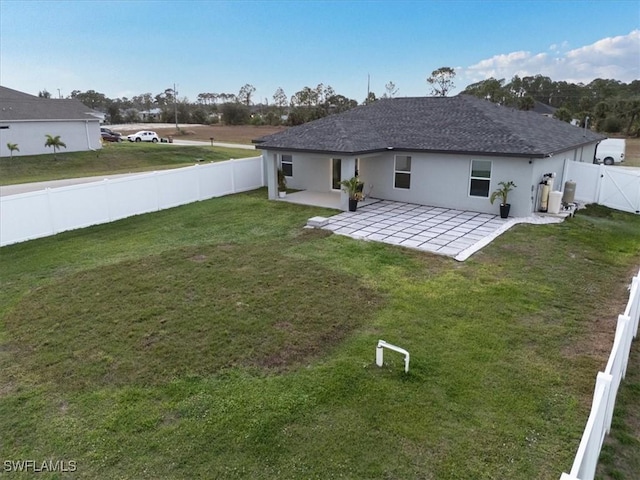 rear view of property featuring a patio and a lawn