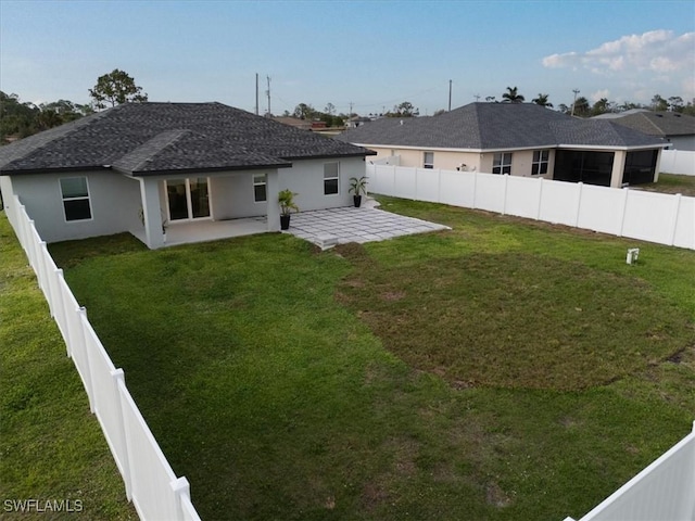 rear view of property with a lawn and a patio area